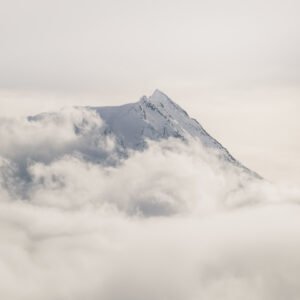 Snowy mountain peak floating over the clouds